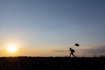 Fototapeta na wymiar Brave mountaineer carrying the flag on top
