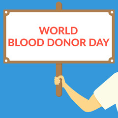 WORLD BLOOD DONOR DAY. Hand holding wooden sign