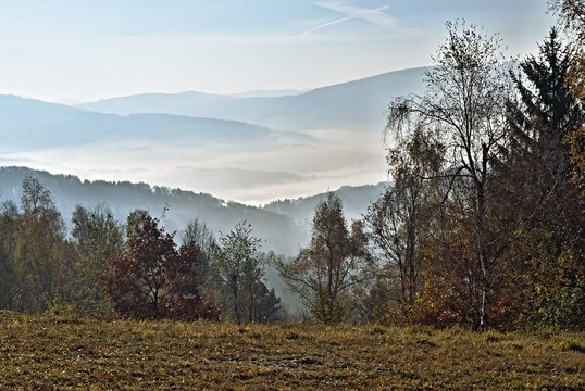 Fototapeta Autumn landscape with fog and hills on the horizon