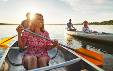 Smiling couple canoeing with friends on a late summer afternoon