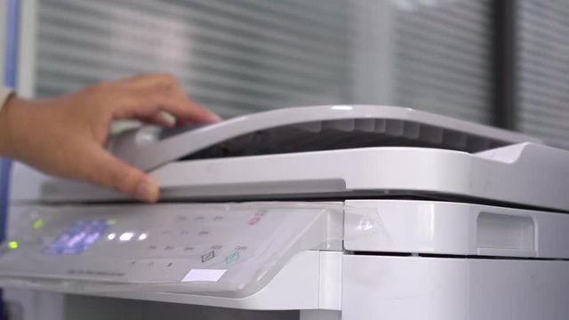 Business office Concept : Hand Businessman is process of press paper on laser print cartridge, lay down or take papers from printer at Busy Offices background