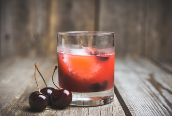 Old fashioned cocktail with cherry. Selective focus.