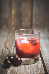 Old fashioned cocktail with cherry. Selective focus.