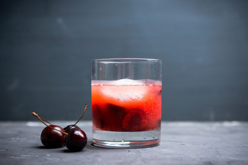 Old fashioned cocktail with cherry. Selective focus.