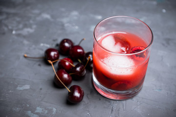 Old fashioned cocktail with cherry. Selective focus.