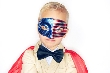 Cute little boy wearing a superhero cape and flag mask