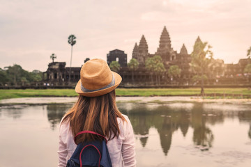 Fototapeta premium Młoda kobieta podróżująca patrząc na Angkor Wat, dziedzictwo architektury khmerskiej w Siem Reap w Kambodży