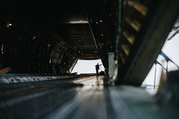 Silhuette eines Arbeiters in einem leeren Antonov Frachtflugzeug