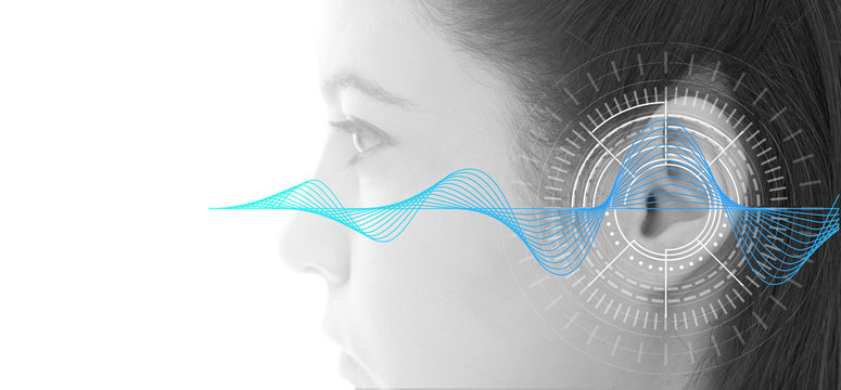 Hearing test showing ear of young woman with sound waves simulation technology