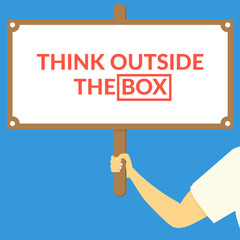 THINK OUTSIDE THE BOX. Hand holding wooden sign