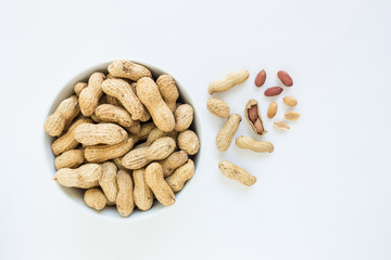 peanut pile in white bowl top view on white background