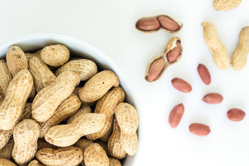peanut pile in white bowl top view on white background