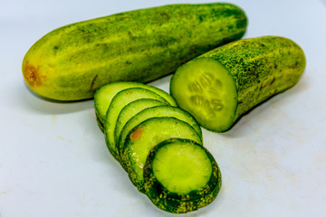 Cucumber and slices isolated over white background.