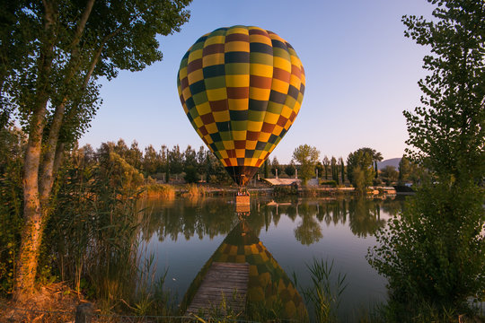Mongolfiera colorata in volo sopra al lago