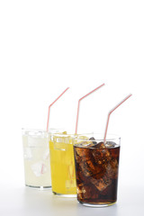 Fototapeta na wymiar Refrescos de cola, naranja y limón en vaso con pajita sobre fondo blanco