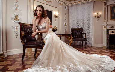 Sensual brunette bride in luxury wedding dress over classic interior, fashion beauty portrait