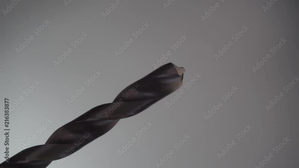 Poster Metal drill bit rotation on a dark background. Macro view.
