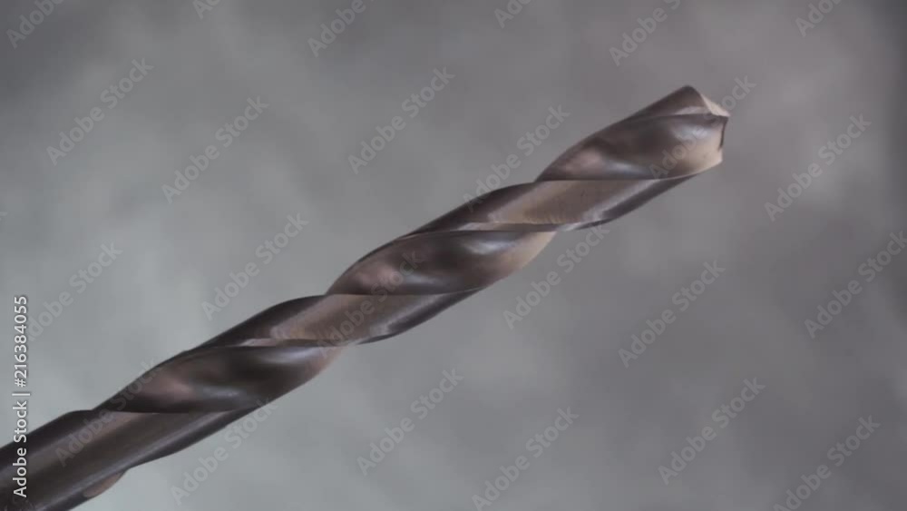 Aufkleber metal drill bit rotation on a dark background. macro view.