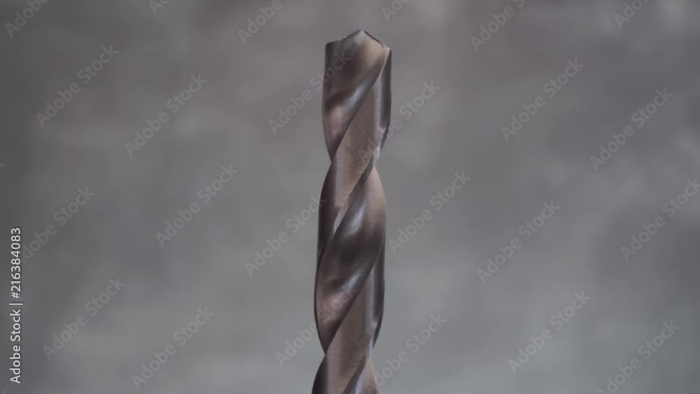 Poster Metal drill bit rotation on a dark background. Macro view.
