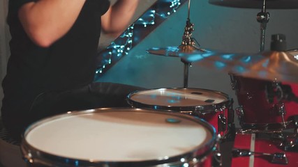 Artist Playing Drums in a Room with Beautiful Lights in the Background. Close Up