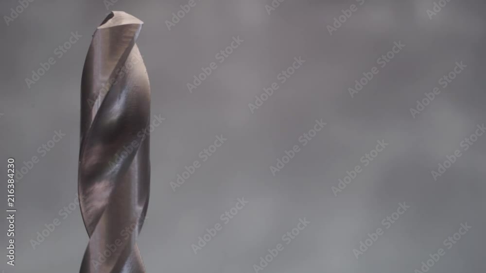 Aufkleber metal drill bit rotation on a dark background. macro view.