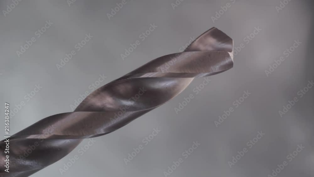 Poster Metal drill bit rotation on a dark background. Macro view.