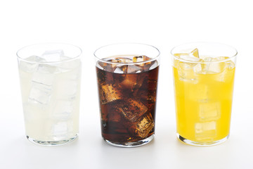 Vasos con refrescos de cola, naranja y limón