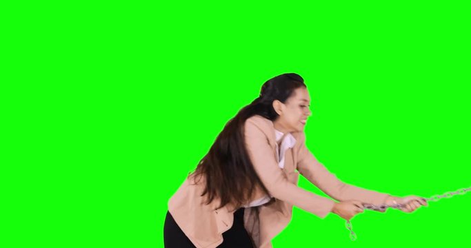Young businesswoman pull a chain in the studio. Concept of business competition for win. Shot in 4k resolution with green screen background