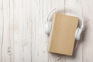 Fototapeta premium Audiobook concept with old book and headphones