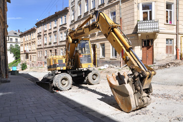 Wheel excavator performs road repairs on the streets of the old city