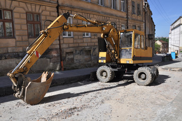 Wheel excavator performs road repairs on the streets of the old city
