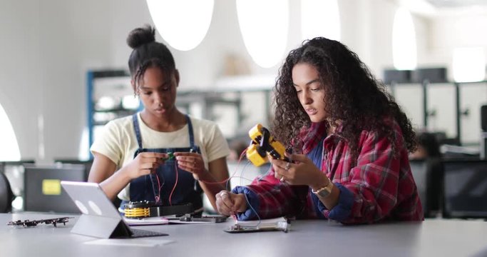 High school students working on a robotic arm in class