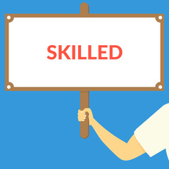 SKILLED. Hand holding wooden sign