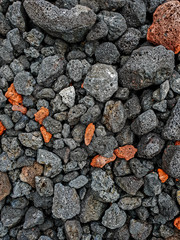 Red and black lava stones on the ground. background. Flat lay 