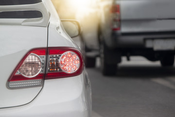 Fototapeta premium White car with break light stop on the road by traffic jam from junction light control.