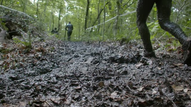 people running a mud race high speed and slow motion