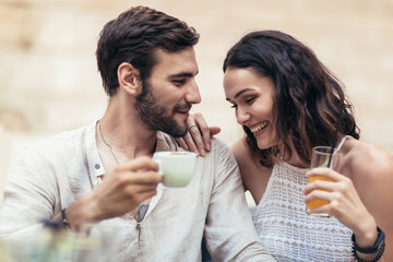 Beautiful loving couple sitting in a cafe enjoying in coffee and conversation.