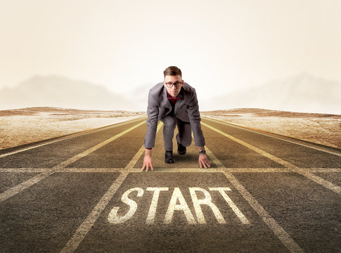 Young determined businessman kneeling before start line - Powered by Adobe