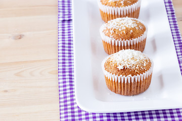 Homemade vanilla muffins with coconut powder. Pink background. Copy space. Selective focus. Blur motion.