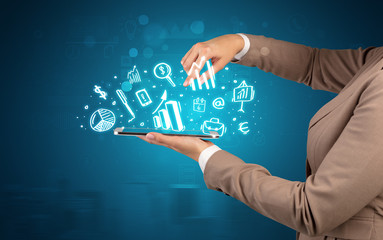 Elegant hand holding tablet with chalk drawn social media symbols above
