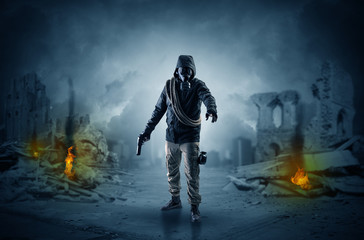 Fototapeta premium Destroyed place after a catastrophe with man in gas mask and weapon on his hand 
