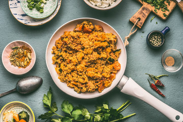 Healthy vegetarian couscous dish with ingredients : vegetables, herbs on dark background, top view, flat lay.