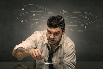 Young drunk man at his office with doodles around
