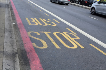 Bus stop sign on road, London, UK.