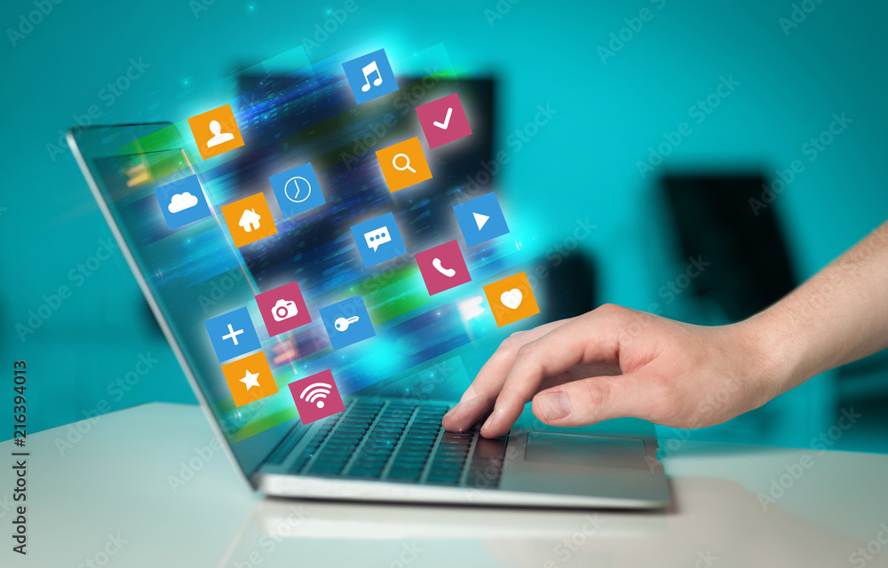 Poster Hand using laptop with colorful fast moving application icons and symbols concept
