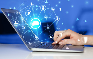 Hand using laptop with centralized cloud computing system and network security concept
