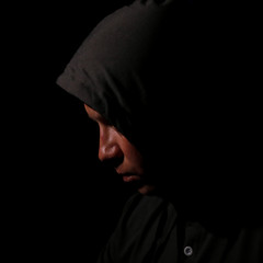 The man's portrait in a hood in the dark.