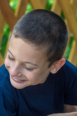 Obraz premium A child sick with infantile cerebral palsy outdoors in the village smiles and looks down.