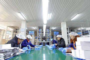 Workers in the PVC gloves production lines in a factory