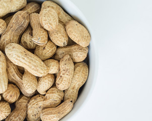 peanut pile in white bowl top view on white background